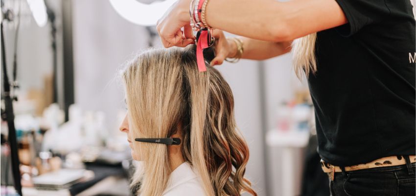 Blonde hair being sectioned and styled as part of a protective olaplex perm process.