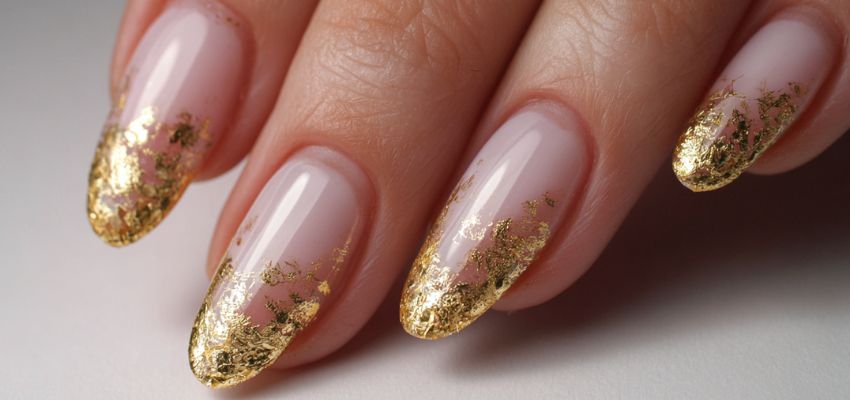 Woman displaying gold-flake acrylic French tip nail designs with a stylish, elegant finish.