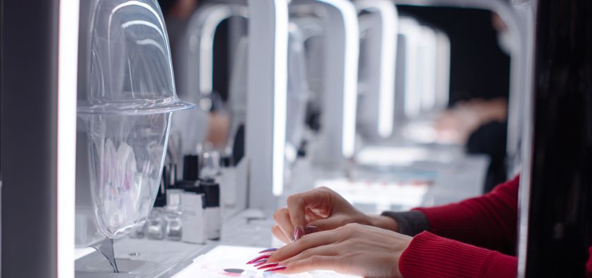 Modern nail pod stations with LED lighting where clients receive manicures at individual manicure desks.