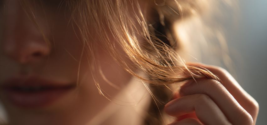 The woman checked the thickness of her hair.