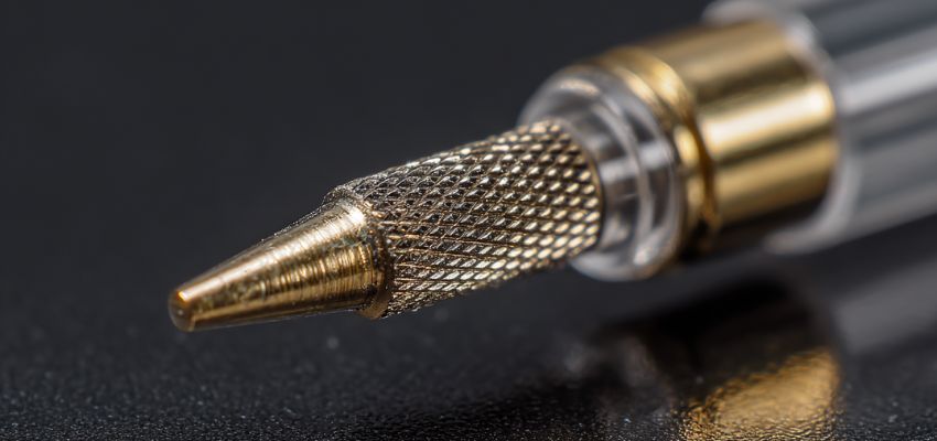 Close-up of a pointed gold nail drill bit showing details from different nail drill bits explained