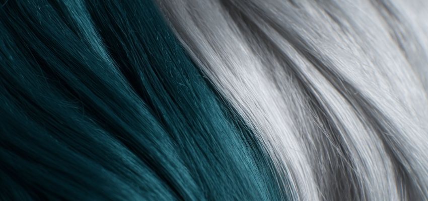 Striking close-up of split dye hair ideas featuring deep teal on one side and shimmering silver on the other, showing smooth color division